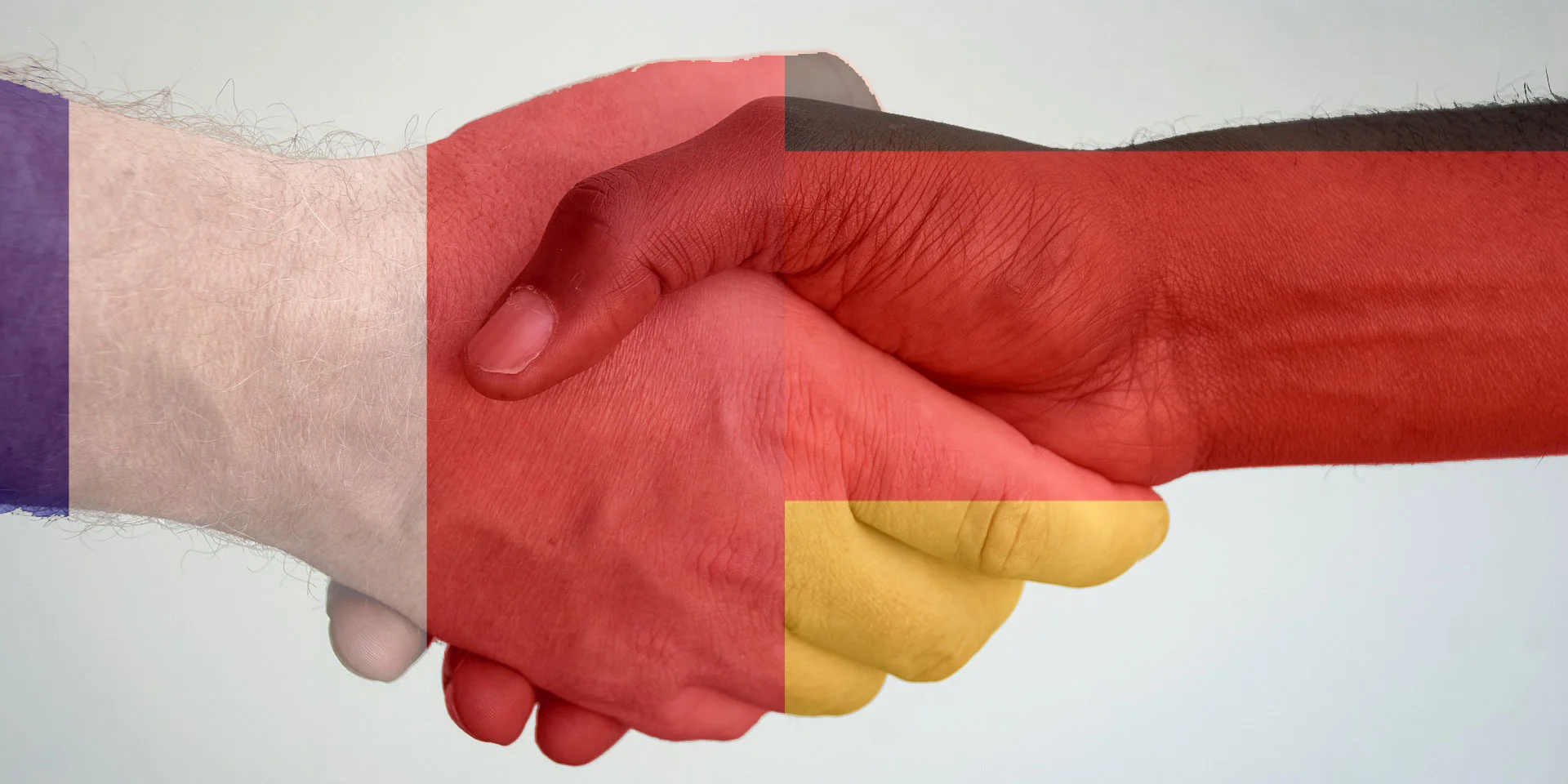 Händeschütteln mit den Flaggen von Frankreich und Deutschland im Hintergrund